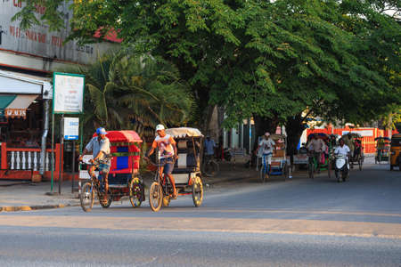 TOAMASINA, MADAGASCAR - OCTOBER 17, 2016: Traditional rickshaw bicycle with malagasy peoples in Madagascar second largest city Toamasina. Ordinary street life in Toamasina, Madagascar October 17. 2016のeditorial素材