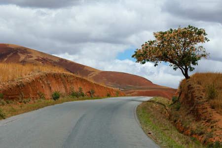 Road through Madagascar highland countryside landscape. Deforestation in Madagascar creates agricultural or pastoral land but can also result ecology problem. Madagascar Mahajanga Provinceの写真素材
