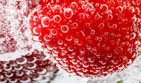 fresh strawberry in glass with sparkling water isolated on white background