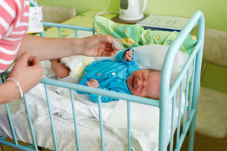 crying newborn baby infant in the hospital, the first hours of the new life, one days after birth