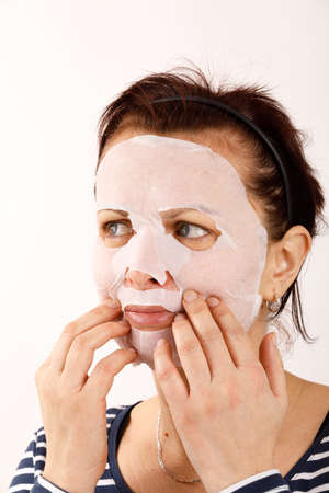 ordinary middle-aged housewife woman with cosmetic sheet mask on her face