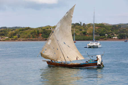NOSY BE ,MADAGASCAR - NOVEMBER 3.2016 Malagasy man on sea in traditional handmade dugout wooden sailing boat. Everyday life on Nosy be island. Nosy be, Madagascar, November 3. 2016のeditorial素材