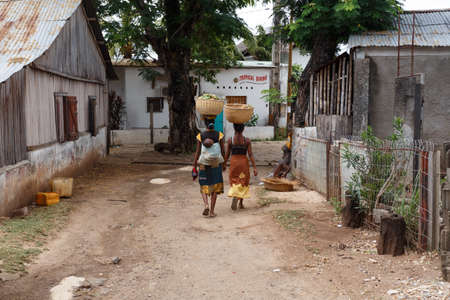 NOSY BE ,MADAGASCAR - NOVEMBER 3.2016 Malagasy women traditionally carry a basket of fruit on their heads. Nosy be, Madagascar, November 3. 2016のeditorial素材