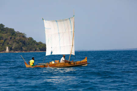 NOSY BE ,MADAGASCAR - NOVEMBER 3.2016 Malagasy man on sea in traditional handmade dugout wooden sailing boat. Everyday life on Nosy be island. Nosy be, Madagascar, November 3. 2016のeditorial素材