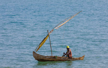 NOSY BE ,MADAGASCAR - NOVEMBER 3.2016 Malagasy man on sea in traditional handmade dugout wooden sailing boat. Everyday life on Nosy be island. Nosy be, Madagascar, November 3. 2016のeditorial素材