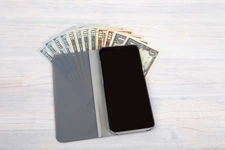 cellular phone and American dollars money on retro vintage wooden background, money concept, expensive billの写真素材