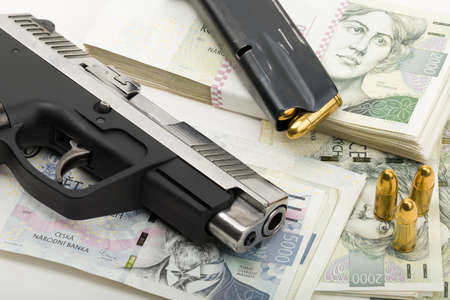 gun and czech banknotes nominal value two and five thousands, corruption crime concept