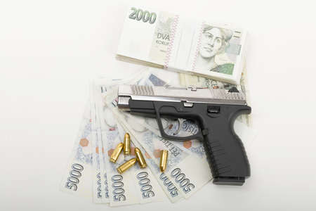 gun and czech banknotes nominal value two and five thousands, corruption crime concept