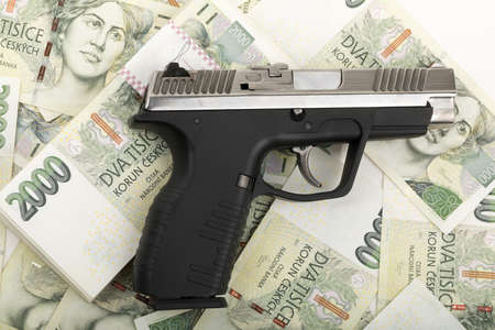 gun and czech banknotes nominal value two and five thousands, corruption crime conceptの写真素材