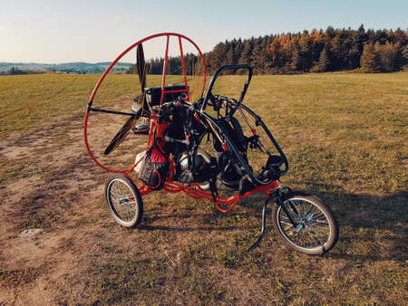 Powered paragliding vehicle on field with green grass, prepared for the flying