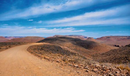 endless empty sand road in fantastic central Namibia desert landscape, traditional african sceneryの写真素材