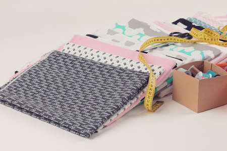 Stack of 100% cotton fabric material for tailor or homework, sewing concept with yellow tailor's...