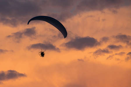 Parachutist falling from the sky in evening sunset dramatic sky. Recreational sport, Paratrooper...