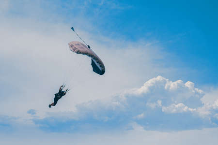 Parachutist falling from the sky in evening sunset dramatic sky. Recreational sport, Paratrooper silhouette on colored sky.の写真素材