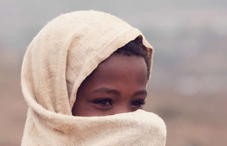 AMHARA REGION, ETHIOPIA, APRIL 22.2019, Beautiful Ethiopian Amhara girl hides her face behind a scarf. Amhara Region, Ethiopia, April 22. 2019のeditorial素材