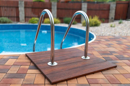 small home swimming pool with two black sun loungersの写真素材