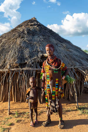 Turmi, Omo River Valley, Ethiopia - May 10, 2019: Portrait of a Hamar woman and children in village....