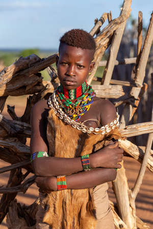 Turmi, Omo River Valley, Ethiopia - May 10, 2019: Portrait of a Hamar woman in village. The Hamer are a primitive tribe and the women have many decorations. South Ethiopia Africaのeditorial素材