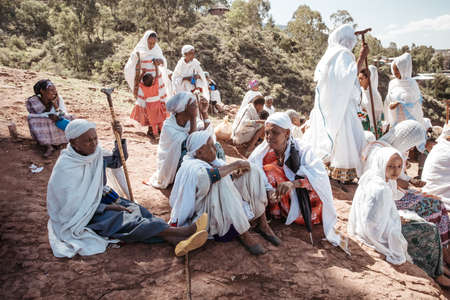 LALIBELA, ETHIOPIA, MAY 1st. 2019, Orthodox Christian Ethiopian woman believer in front of famous rock-hewn St. George's Church after Mass on May 1st. 2019 in Lalibela, Ethiopiaのeditorial素材