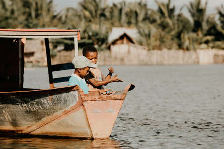 MADAGASCAR OCTOBER 18.2016 Young boys catch fish with fishing line in Antainambalana river. Maroantsetra October 18. 2016, Madagascar.のeditorial素材