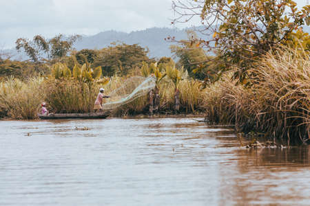 MAROANTSETRA, MADAGASCAR OCTOBER: 19.2016: Native malagasy man fishing on river, using technique pulling net from boat. Daily life of peoples in Madagascar countryside. October 19. 2016, Madagascarのeditorial素材