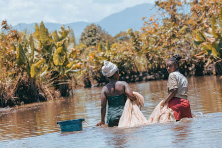 MAROANTSETRA, MADAGASCAR OCTOBER: 19.2016: Malagasy woman fishing on river, using technique pulling net from water. Daily life of peoples in Madagascar countryside. October 19. 2016, Madagascarのeditorial素材