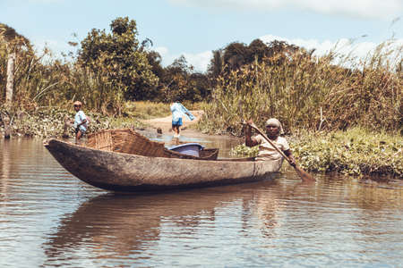MAROANTSETRA, MADAGASCAR OCTOBER 19.2016: Malagasy people transport freight by traditional handmade wooden pirogue. Daily life on the river Antainambalana. Maroantsetra October 19. 2016, Madagascar.のeditorial素材
