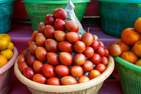 Tamarillo, fruit in plastic basket on street marketplace, farmers market in bali Indonesiaの写真素材