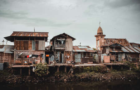 MANADO, NORTH SULAWESI, INDONESIA - AUGUST 3, 2015: View of a ghetto by a river with pollution, the...