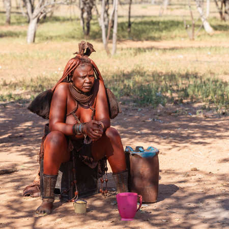 NAMIBIA, KAMANJAB, MAY 6: Bored Himba women in village posing to tourists near Kamanjab in northern Namibia, May 6, 2018, Namibiaのeditorial素材