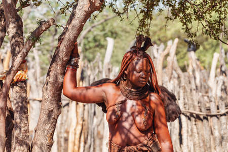 NAMIBIA, KAMANJAB, MAY 6: Bored Himba women in village posing to tourists near Kamanjab in northern...