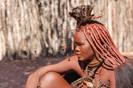 NAMIBIA, KAMANJAB, MAY 6: Bored Himba women in village posing to tourists near Kamanjab in northern...
