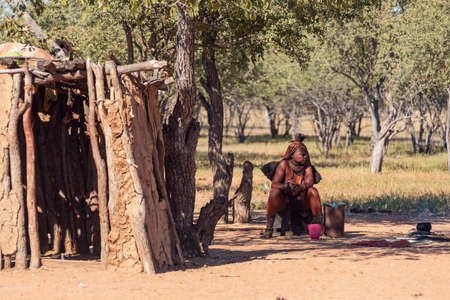 NAMIBIA, KAMANJAB, MAY 6: Bored Himba women in village posing to tourists near Kamanjab in northern...