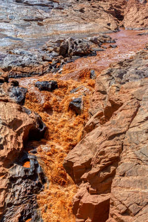Rocky river bed Betsiboka river after heavy rain, fast red yellow water stream, northern Madagascar landscapeの写真素材