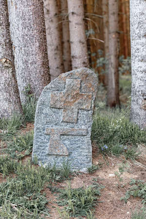 Old boundary marker on rock at forest. On stone carved symbol of cross and ax. Czech Republicの写真素材
