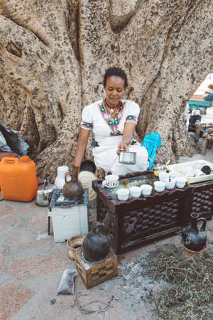 AXUM, ETHIOPIA, APRIL 27th.2019: Ethiopian native women prepare street bunna coffee under big tree...