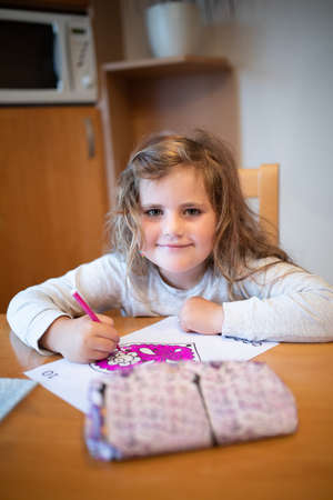 Smiling happy cute girl with long curly golden hair artist painting picture on paper. School...