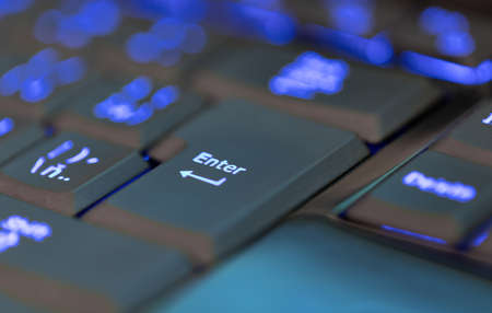 Closeup of laptop or desktop computer keyboard illumination, blue backlit keyboard. Focus to key...