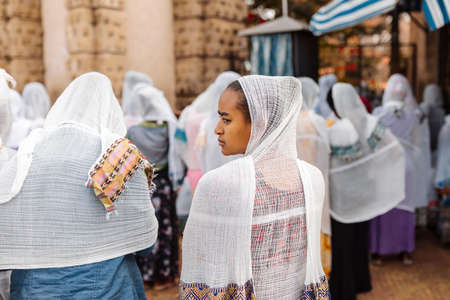 Azezo, Amhara Region, Ethiopia - April 21, 2019: Orthodox Christian people white dressed walk to mass on the street during easter holiday. Bahir dating in Dar, Ethiopiaのeditorial素材