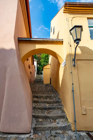 Narrow picturesque street with colorful buildings in historic center in medieval city Trebic, aisle...