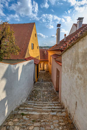 Narrow picturesque street with colorful buildings in historic center in medieval city Trebic, aisle in renaissance and baroque historical buildings at jewish quarter. Czech Republicの写真素材