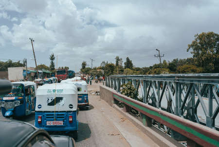 Meki, Oromia Region, Ethiopia - May 16, 2019: Cars and rickshaw known as Tuk tuk Meki on main street of Meki, Oromia Region, Ethiopia, Africaのeditorial素材