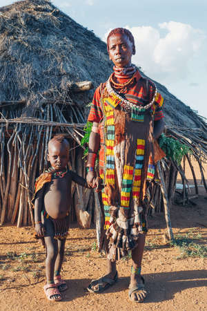 Turmi, Omo River Valley, Ethiopia - May 10, 2019: Portrait of a beautiful woman with children in Hamar village. Hamars are the original tribe in southwestern Ethiopia. South Ethiopia Africaのeditorial素材