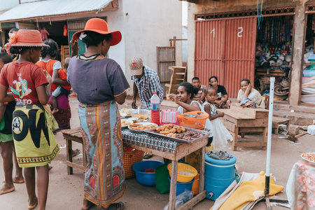 Miandrivazo, Madagascar - November 1, 2022: Street food seller on the main street in Miandrivazo. In Madagascar, people usually eat on the street.のeditorial素材