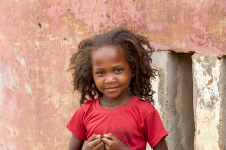 Bekopaka - Antsalova, Madagascar- November 6, 2022: Small cute Malagasy girl with long hair, happy little dancer on celebration in village Bekopaka, region of Melaky, Madagascar.のeditorial素材