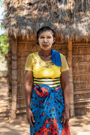 Belo Sur Tsiribihina, Madagascar - November 4, 2022: Malagasy woman in front of her hut with a traditionally painted face. Malagasy women paint their faces to protect their faces from the sun.のeditorial素材