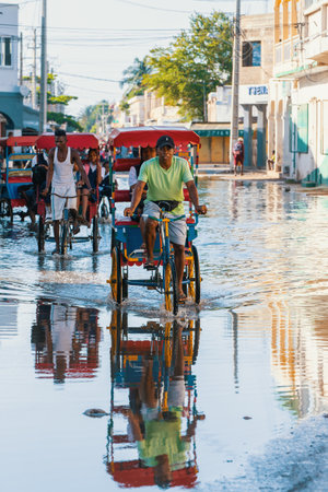 Toliara, Madagascar - November 21, 2022: Traditional rickshaw bicycle with Malagasy passengers on the street, one of the ways to earn money. Everyday life on the city street of Madagascar.のeditorial素材