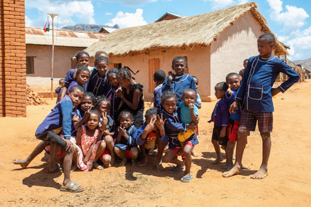 Vohitsaoka, Ambalavao, Madagascar - November 17, 2022: Group of happy Malagasy school children students in front of school. School attendance is compulsory, but many children do not go to school.のeditorial素材
