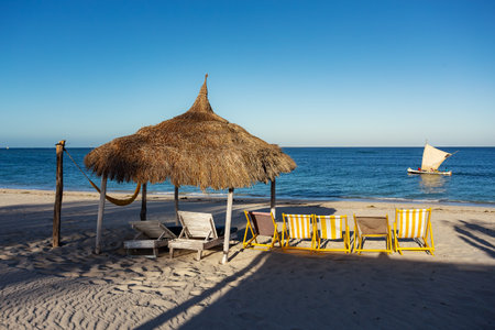 Tranquil and beautiful day on Anakao beach in Madagascar, with a clear blue sky, a comfortable sun lounger, and a colorful parasol for your ultimate relaxation. Toliara, Madagascarの写真素材