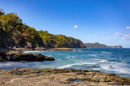 Playa Ocotal with Pacific ocean waves on rocky shore, El Coco Costa Rica. Famous snorkel beach. Picturesque paradise tropical landscape. Pura Vida concept, travel to exotic tropical country.の写真素材